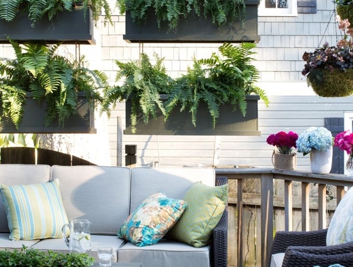 cache balcon décoration extérieure idée cache vue appartement avec plantes suspendues jardinières plantes vertes coussins décoratifs