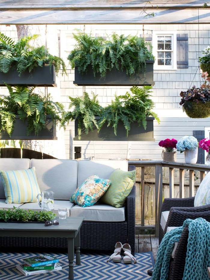 cache balcon décoration extérieure idée cache vue appartement avec plantes suspendues jardinières plantes vertes coussins décoratifs