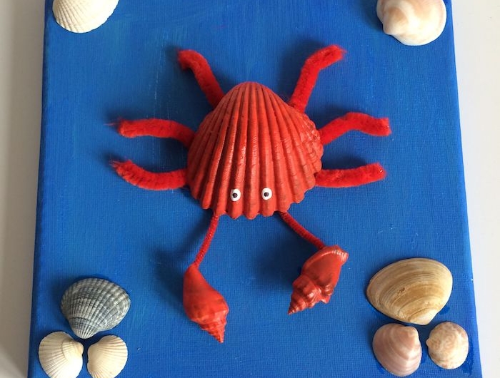 canevas repeint en bleu avec décoration de coquillages de mer et crabe en coquillage et cure pipe activité manuelle été enfant