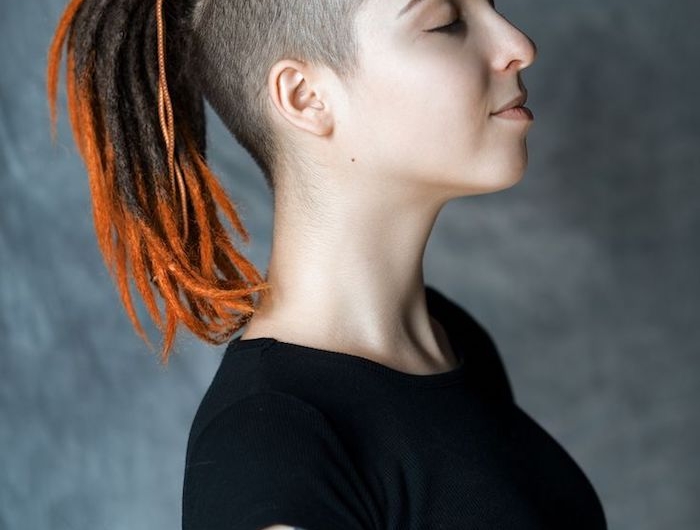 coiffure courte femme tresses africaines avec des bouts orange avec des côtés raséset tee shirt noir