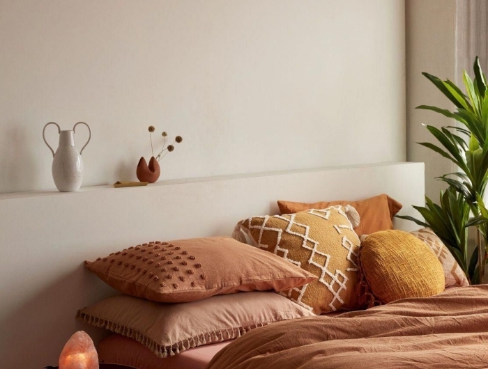 deco couleur terracotta design chambre à coucher boho minimaliste table ronde métal coussin jaune cheddar avec broderie macramé pompons