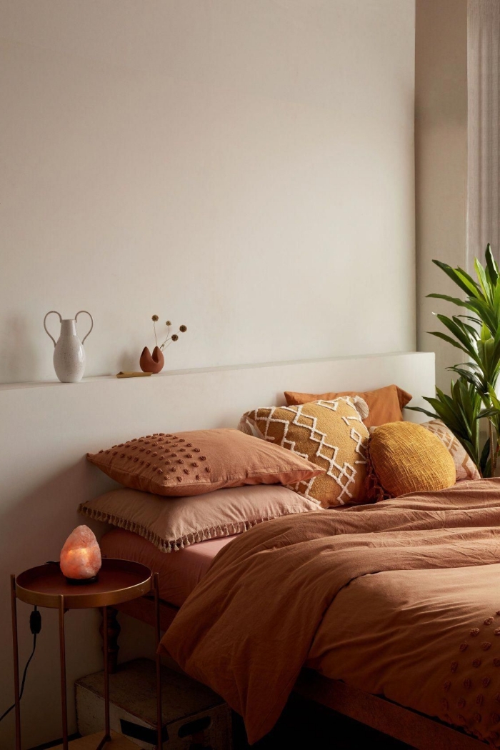 deco couleur terracotta design chambre à coucher boho minimaliste table ronde métal coussin jaune cheddar avec broderie macramé pompons