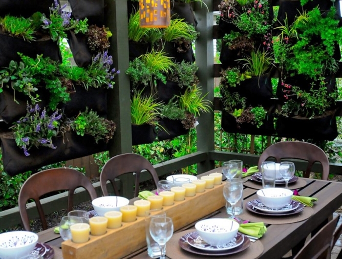 décoration cour arrière pergola meubles extérieur bois foncé table brise vue vegetal éclairage extérieur bougies centre table