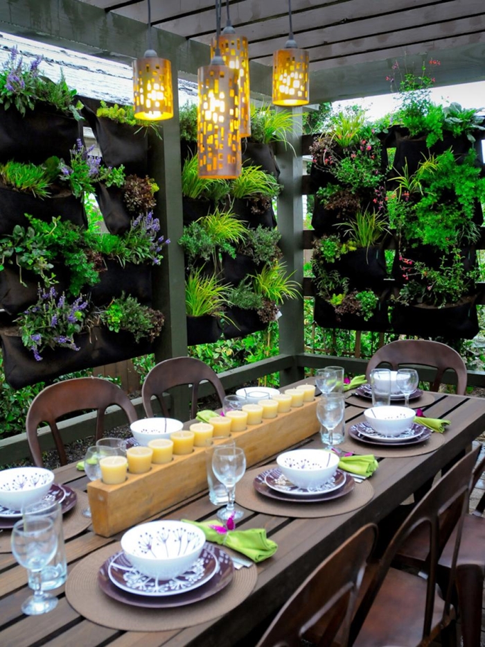 décoration cour arrière pergola meubles extérieur bois foncé table brise vue vegetal éclairage extérieur bougies centre table
