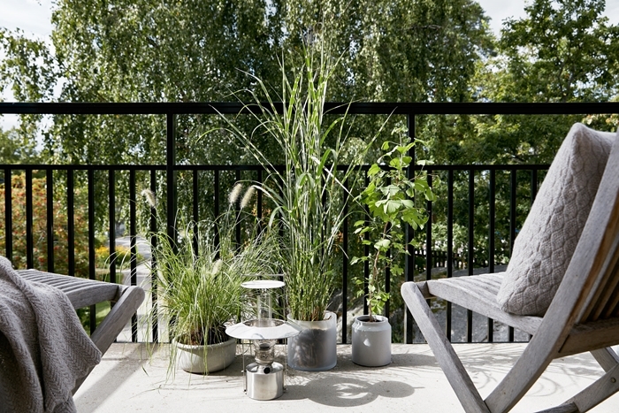 décoration petit balcon extérieur appartement style moderne design chaise bois gris plaid coussin brise vue naturel plantes vertes