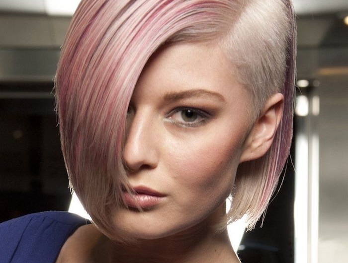 exemple coupe de cheveux court femme mèches rose sur cheveux blond et un côté rasé robe violette