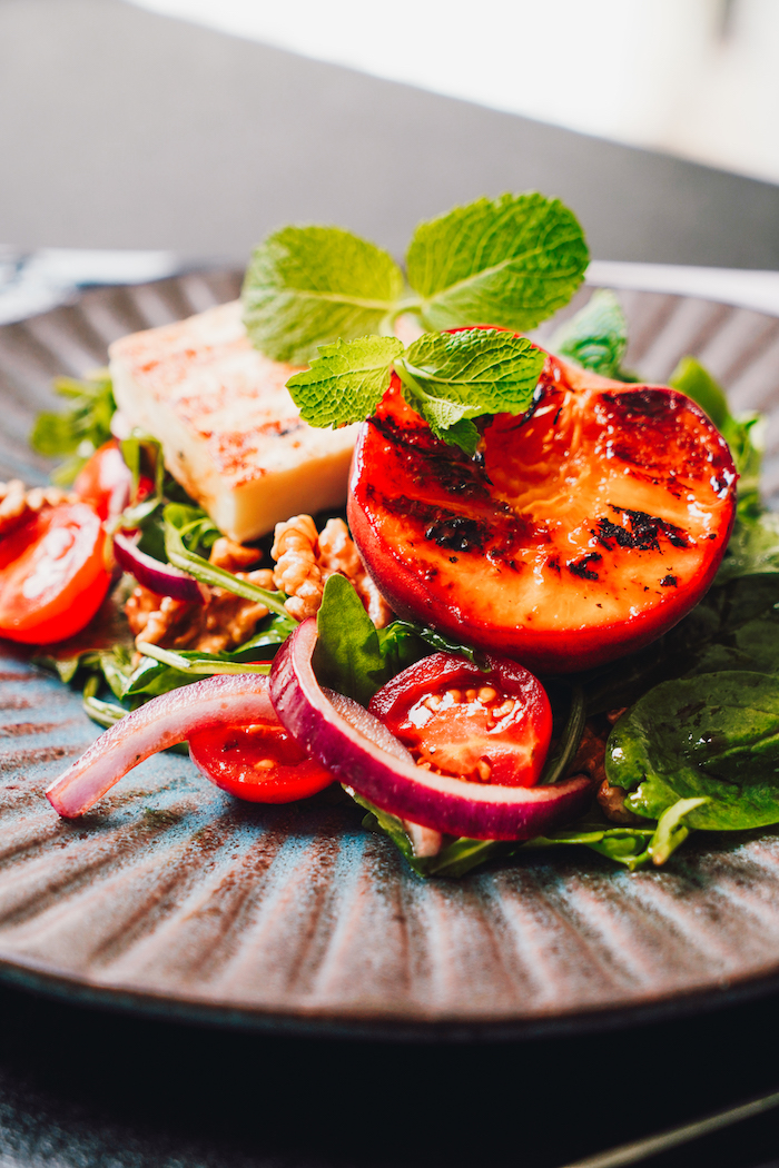 exemple de salade composee excellente avec des épinards roquette pêches oignons rouges noix et halloumi salade originale idée