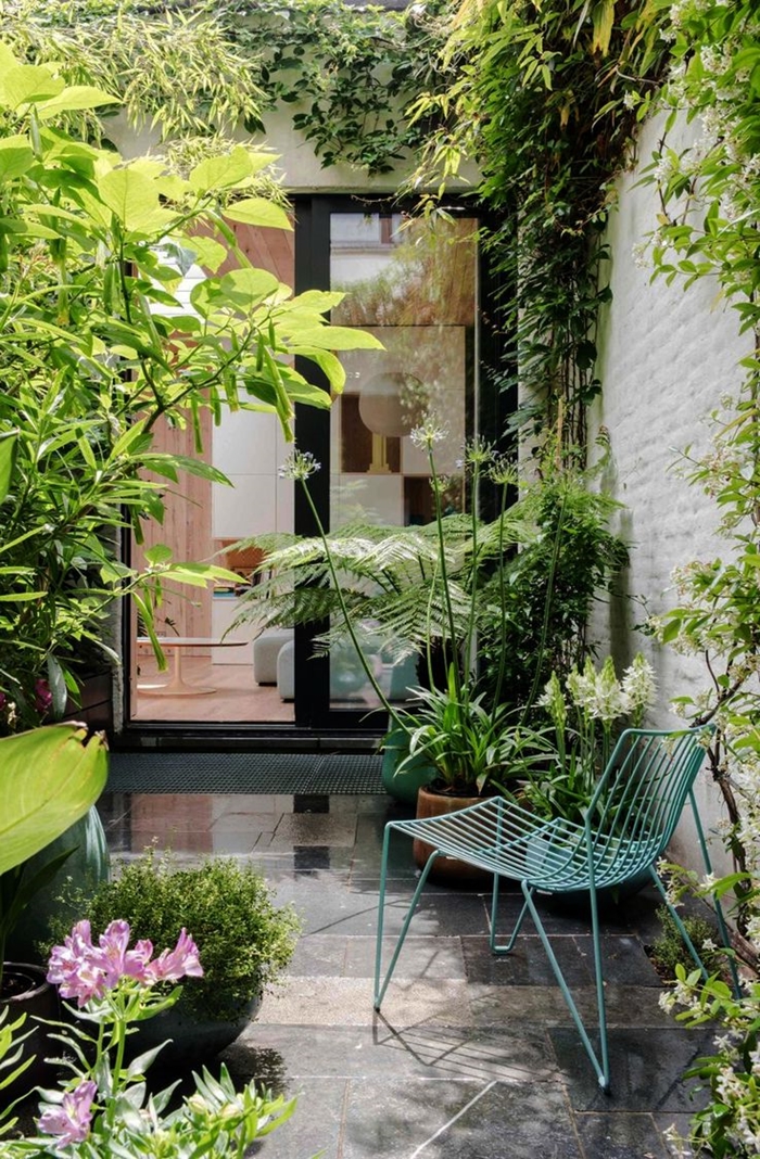 façade maison briques blanches décoration devant maison porte coulissante carrelage chaise métal turquoise brise vue naturel