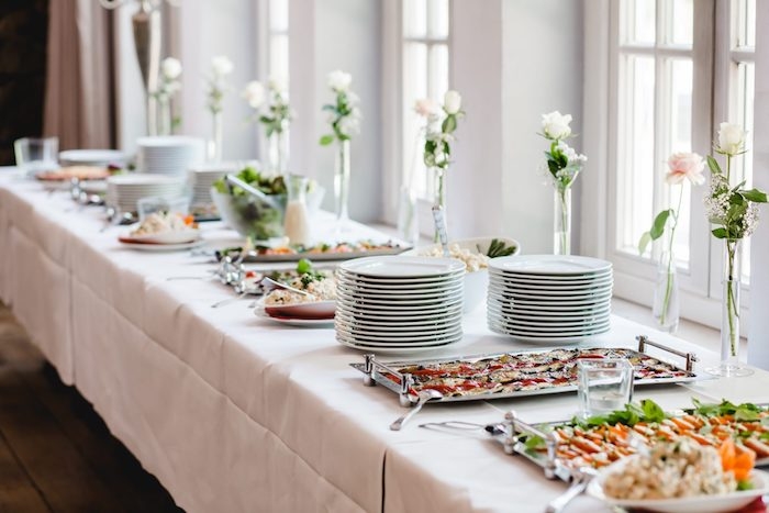 idée de buffet de mariage originale avec des plats exquis pile d assiette sur nappe blanche petits bouquets dans soliflores idee repas mariage simple