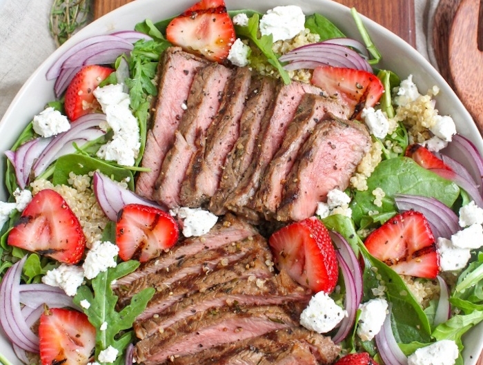 idée repas du soir salade composée à la roquette épinards fraises miettes de fromage feta et steak de porc avec quinoa