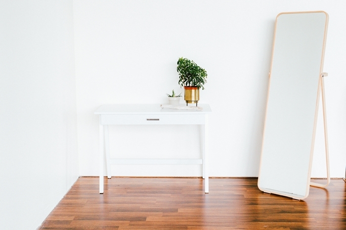 intérieur minimaliste revêtement de sol chois parquet essence bois sol miroir cadre or rectangulaire vase or commode bois blanc