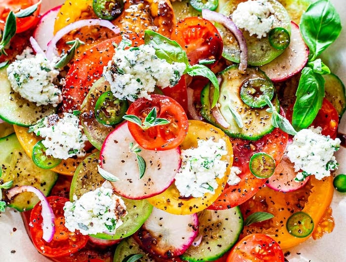 salade de tomates de couleurs variées au basilic avec fromage ricotta aux herbes fraiches et reduction de vinaigre de balsamique