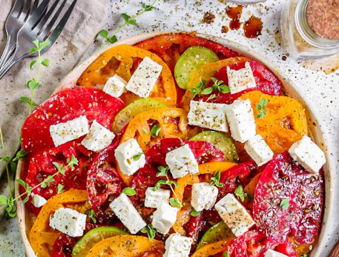 salade de tomates de couleurs variées aux herbes fraiches dont du thym frais et des cubes de feta fromage blanc