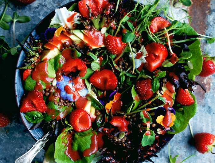 salade froide à la laitue et autres saldes vertes aux fraises et graines avec des fleurs comestibles recette salade d été