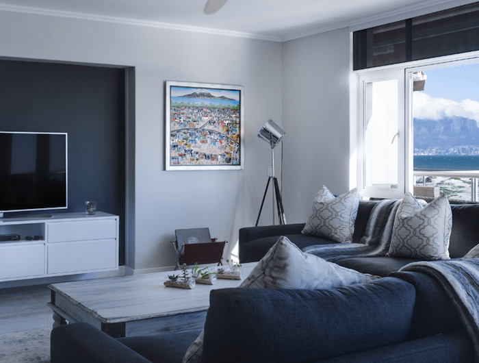 ventilateur de plafond eco plano dans un salon gris avec canapé gris foncé murs gris perle cadre tableau deco table basse bois brut