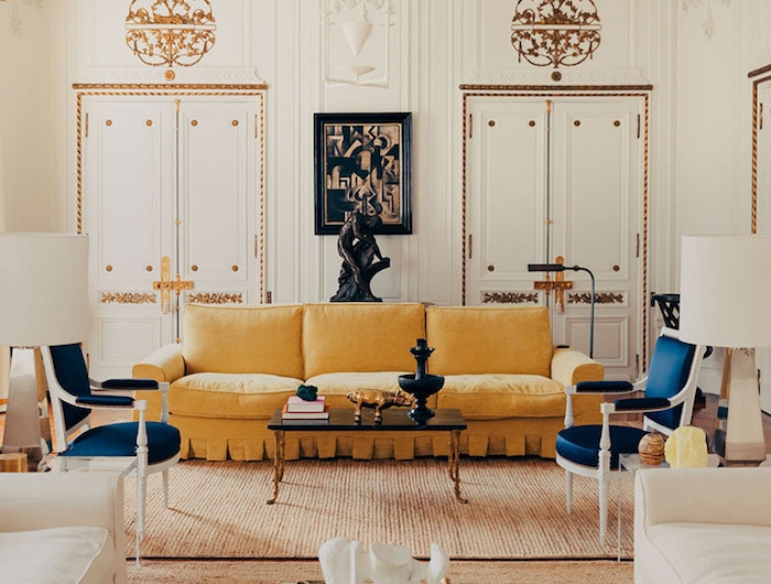appartement design decoration canapé jaune tapis beige chaises blanc et bleu canapés blancs murs blancs et déco murale à accents dorés