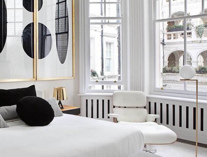 appartement parisien style art deco avec matelas blanc coussins noir et blanc déco murale art abstraite dans encadrement doré grandes fenetres