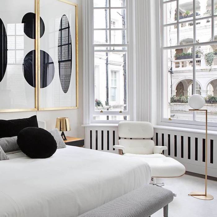 appartement parisien style art deco avec matelas blanc coussins noir et blanc déco murale art abstraite dans encadrement doré grandes fenetres