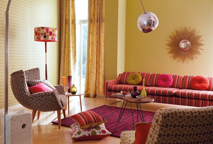 canapé coloré à ayures et papier peint geometrique tapis rouge et violet coussins colorés design année 70 vintage chic