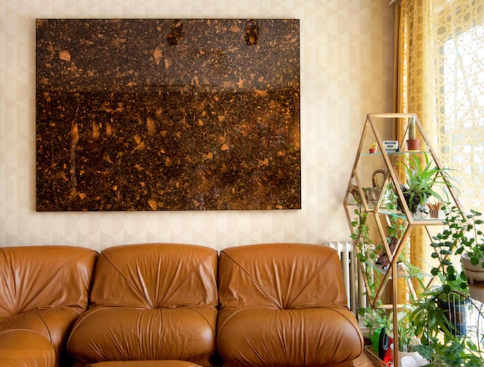 canapé marron clair en cuir tapis style shag coloré étagère surchargée de plantes deco murale psychadélique