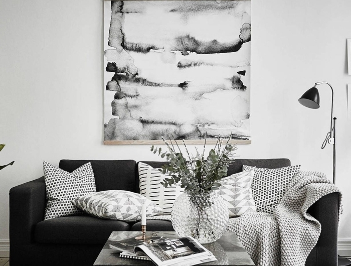 canapé noir tapis gris anthracite table salon basse métal plaid décoratifs coussins tableau noir et blanc lampe sur pied noir mat
