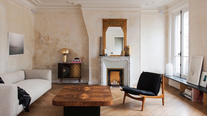 cheminée decorative desing minimaliste dans un appartement parisien de luxe avec canapé gris clair table basse plateau de bois et pied en metal mur effet rouille