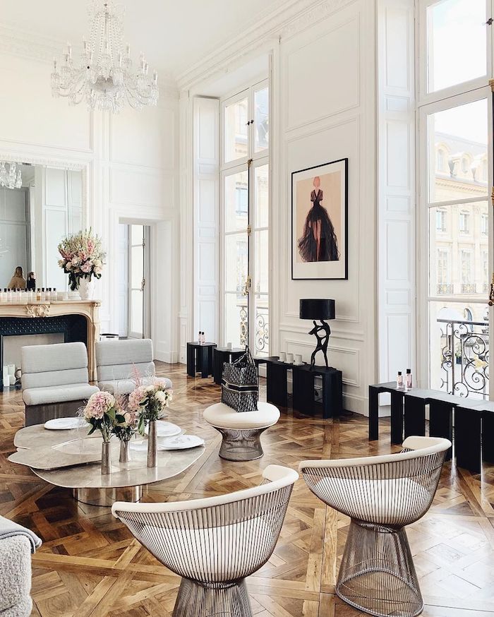 comment decorer un appartement parisien de luxe avec parquet bois fauteuils oeuf table desing metal accents meuble noir fausse cheminée décorative