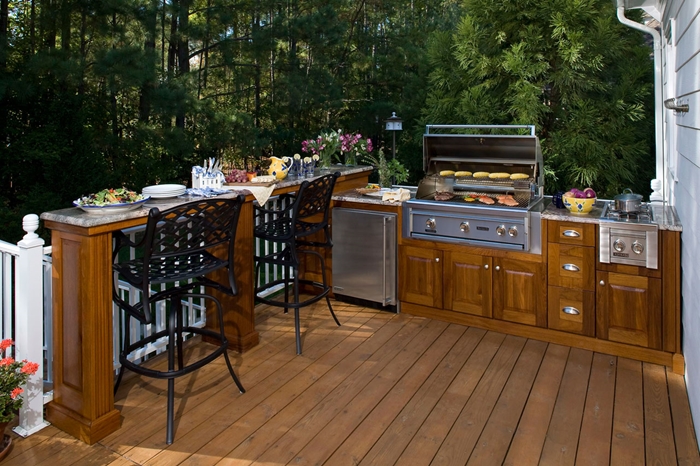 cuisine d été avec bar revêtement de terrasse en bois chaises de bar métal noirci agencement de cuisine en l avec îlot