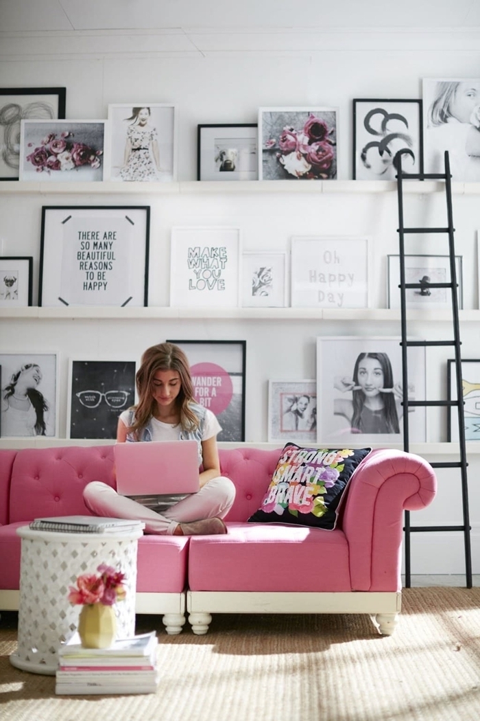 deco murale salon canapé rose boutonné table café ronde blanche étagère bois blanc échelle coussin décoratif multicolore