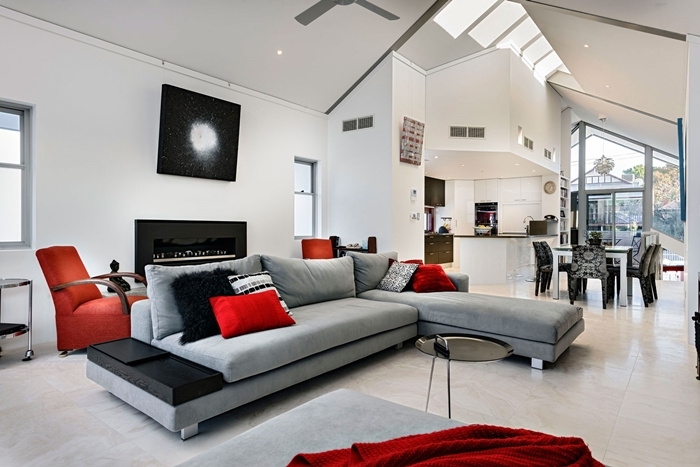 deco noir et blanc design salon sous pente fenêtre de plafond ventilateur coussin rouge canapé gris clair petite cuisine ouverte blanche
