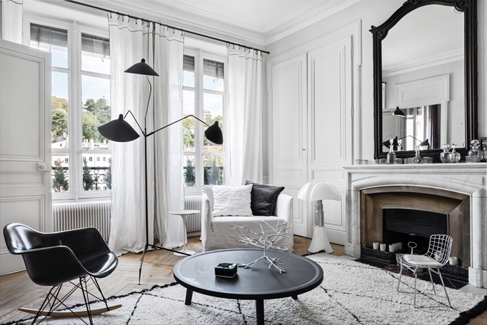 deco salon noir et blanc lampe sur pied noire miroir noir cheminée décorative bougie chaise blanche métal table basse ronde noire