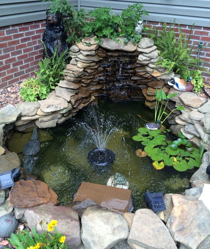 decoration bassin exterieur d angle avec fontaine entouré de pierres et vegetaux verts