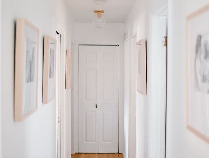 decoration couloir moderne avec des murs blancs parquet clair et deco de cadres avec photos en noir et blanc