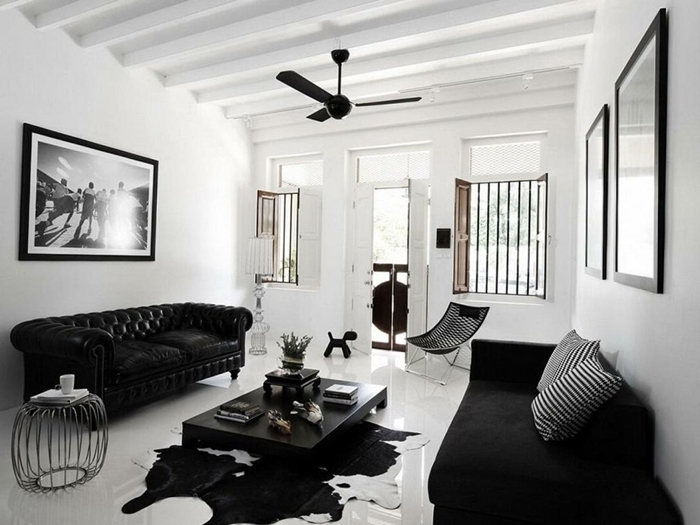 decoration mur interieur salon canapé noir plafond poutres bois apparentes ventilateur de plafond coussins rayures blanc et noir