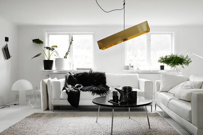 design interieur style minimaliste luminaire or canapé blanc plaid fausse fourrure noire plantes vertes d intérieur deco noir et blanc