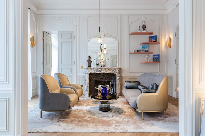 exmeple décoration salon appartement canapé et fauteuils gris tapis fleuri cheminée marbre murs décorés de moulures parquet bois clair