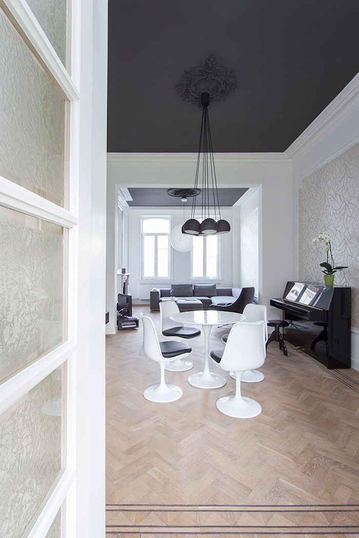 grande chambre table ronde blanche chaises canapé gris piano plafond decoratif comment associer le noir couleur mural lustre comme fleur