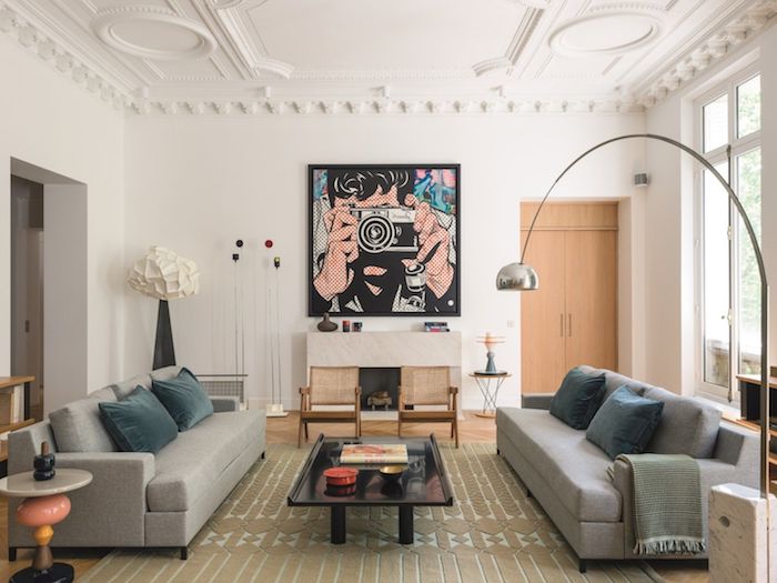 idee de deco salon dans un appartement paris tapis gris canapés gris coussins bleu de gris murs blancs decoration murale photo po art