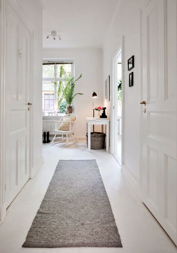 idée deco couloir tout blanc avec des portes blanches et tapis gris meuble table entrée blanche chaise à bascule blanche decoration scandinave maison