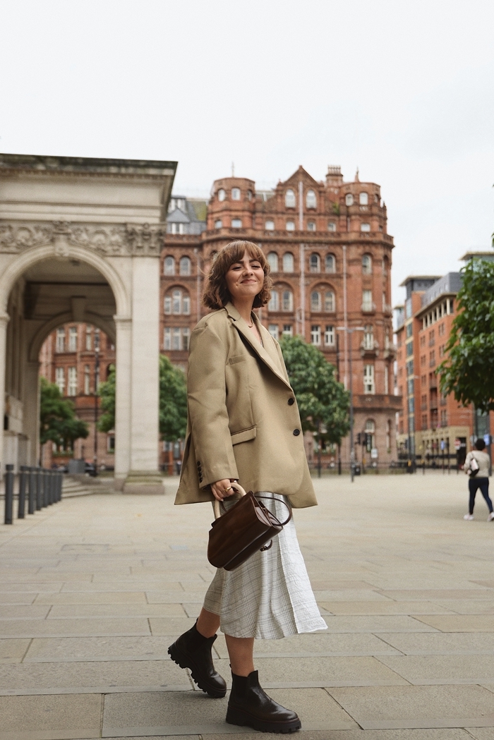 idée de style vestimentaire femme blazer oversize beige jupe blanche fluide bottines cuir noir sac à main cuir marron