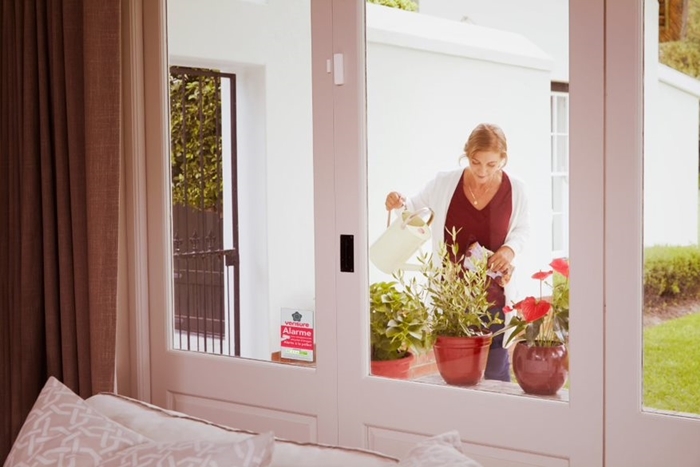 installation alarme sans fil domicile sécurité fenêtre salon rideaux longs vue vers jardin protection contre risque habitation