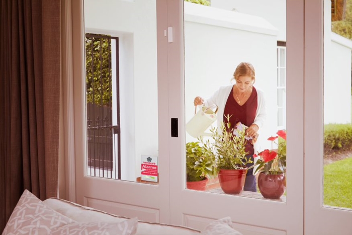 installation alarme sans fil domicile sécurité fenêtre salon rideaux longs vue vers jardin protection contre risque habitation alarmes sans fil
