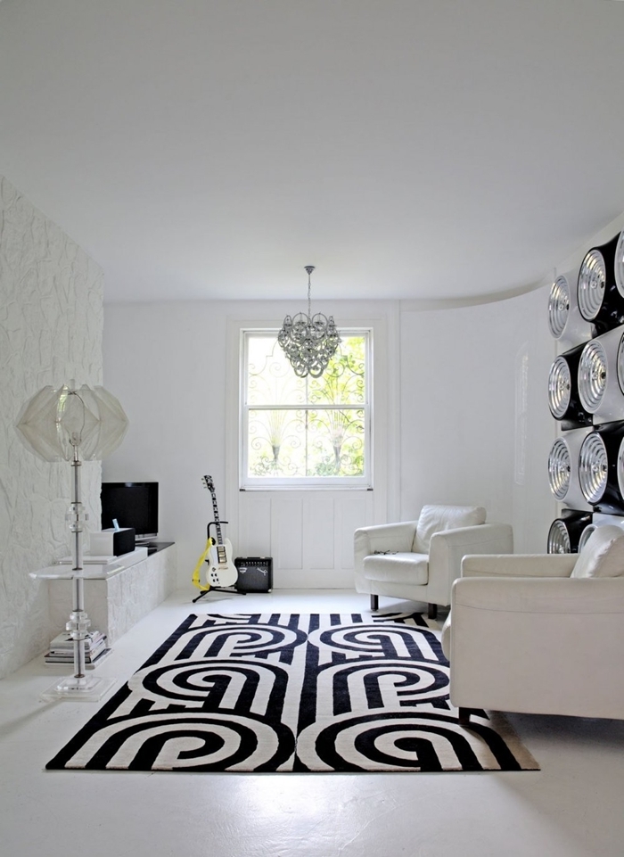 lampe sur pied cristal revêtement mural panneaux blancs salon noir et blanc meubles canapé blanc tapis blanc et noir