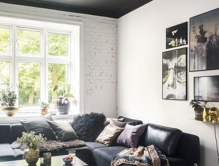 mur briques blanches plafond gris anthracite suspension luminaire or canapé d angle noir mat decoration salon design