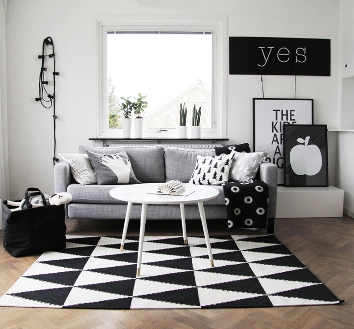 mur de cadres noir et blanc plantes vertes d intérieur canapé gris clair table basse blanche salon bois et noir guirlande lumineuse