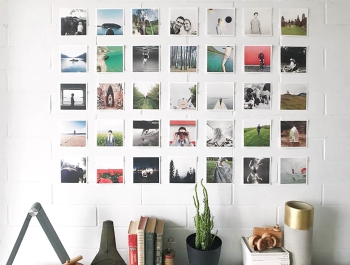 mur de photos déco avec polaroids livres accessoires revêtement mural briques blanches plante verte d intérieur collection cds