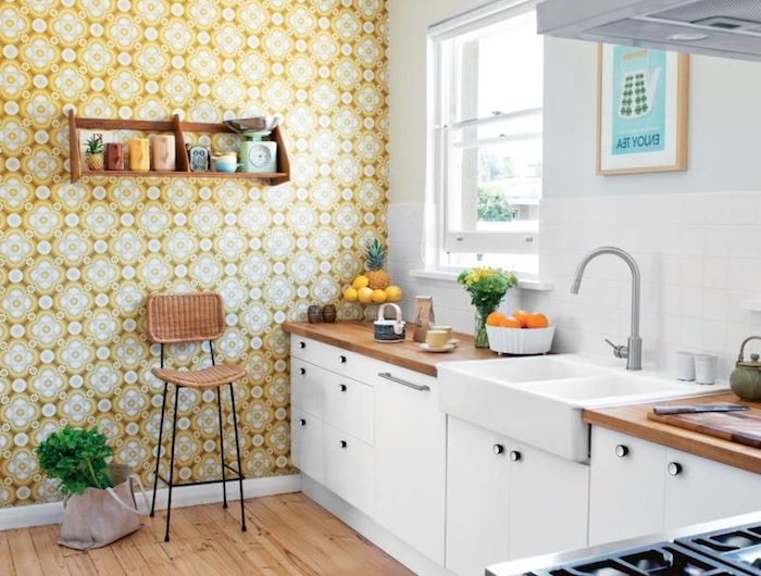 papier peint fleuri sur un mur meuble cuisine bas avec plan de travail bois étagère ouverte surchargée de vaisselle parquet bois clair