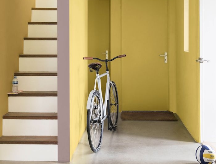 peinture couloir etroit repeint de jaune avec sol gris effet beton et escalier à pas de bois