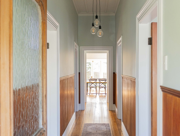 soubassement de bois et peinture couloir etroit vert celadon pastel clair patquet bois vlond usé petit tapis vintage