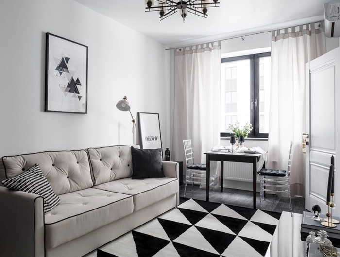 tableau noir et blanc décoration murale minimaliste style intérieur canapé boutonné beige coussin gris anthracite tapis blanc et noir motifs triangulaires